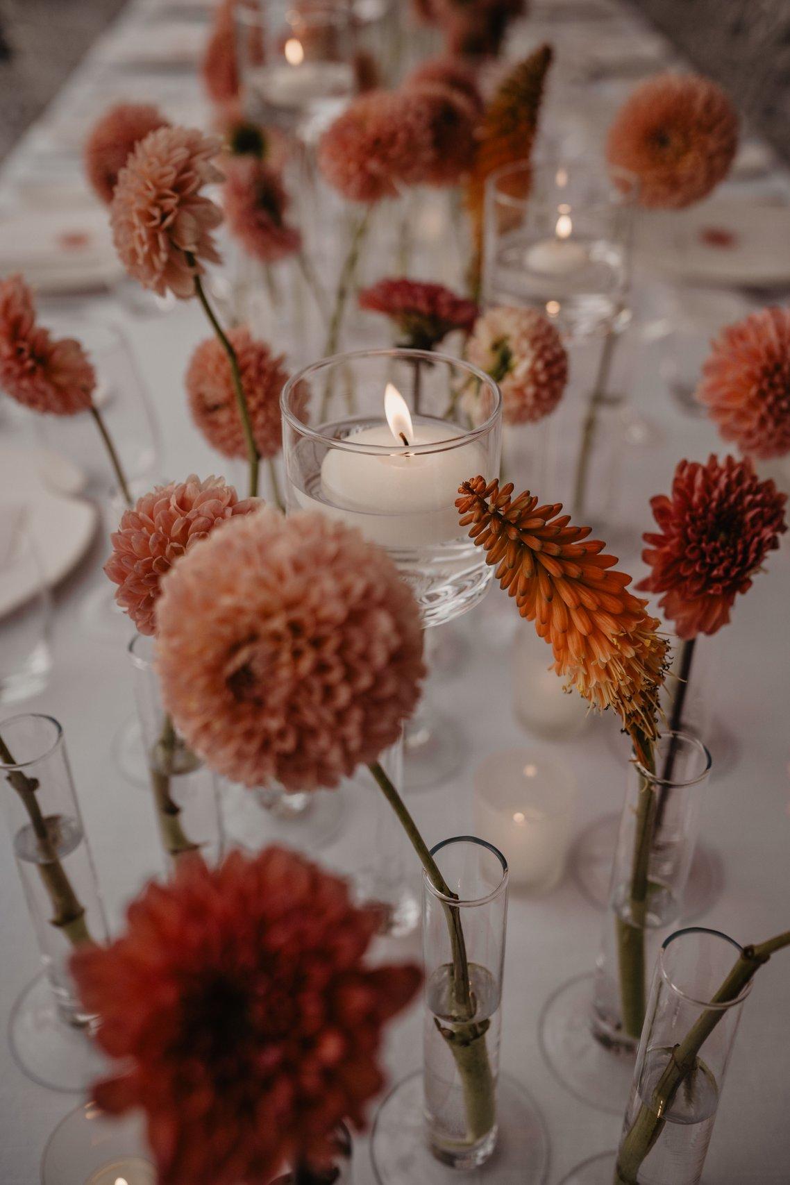 decorazioni floreali color pesca sul tavolo e candele per matrimonio stile editoriale