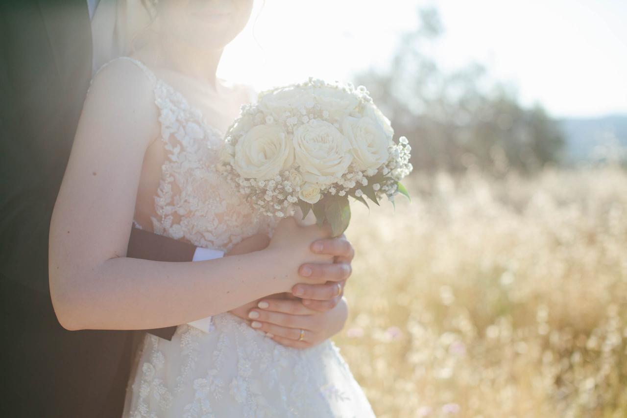 sposi con bouquet rose bianche e gypsophila