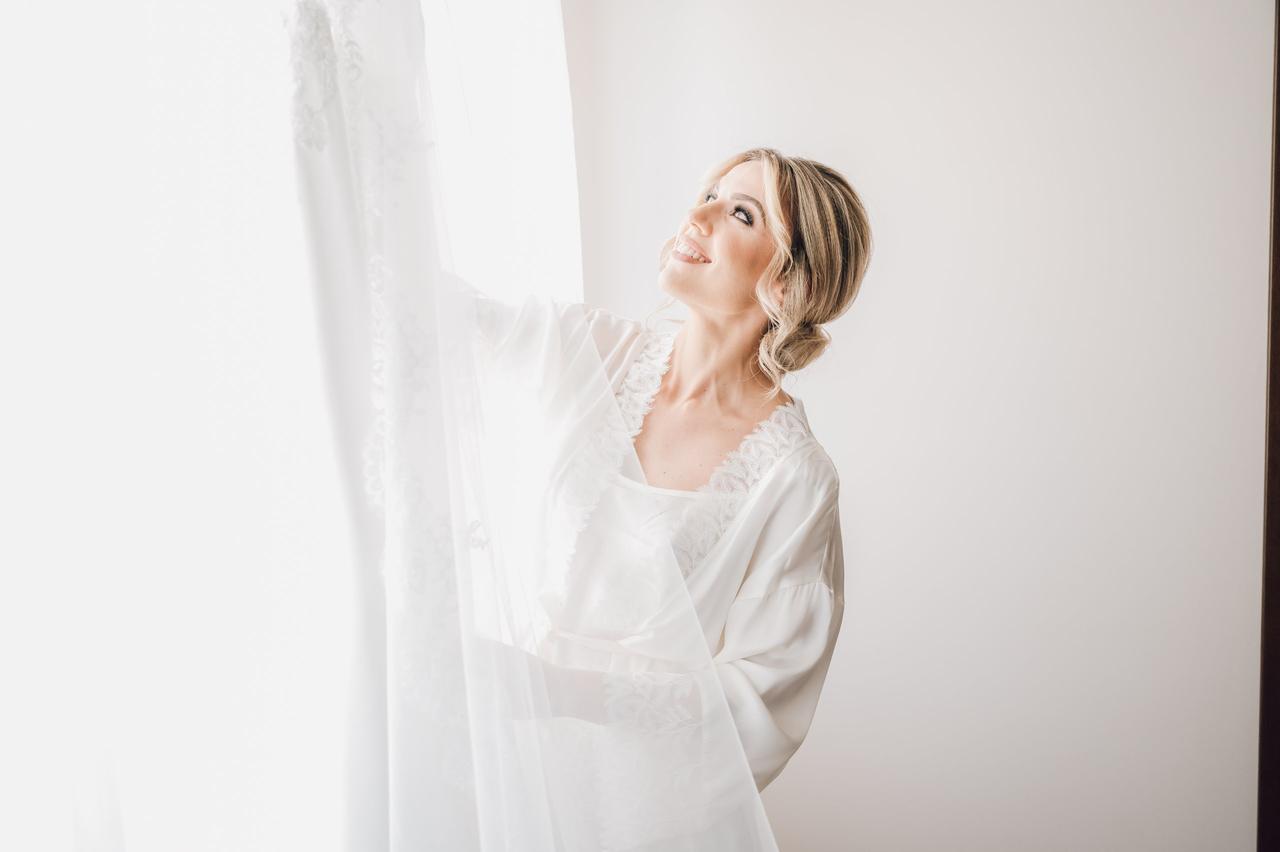 sposa che guarda il suo abito durante la prova abito sposa