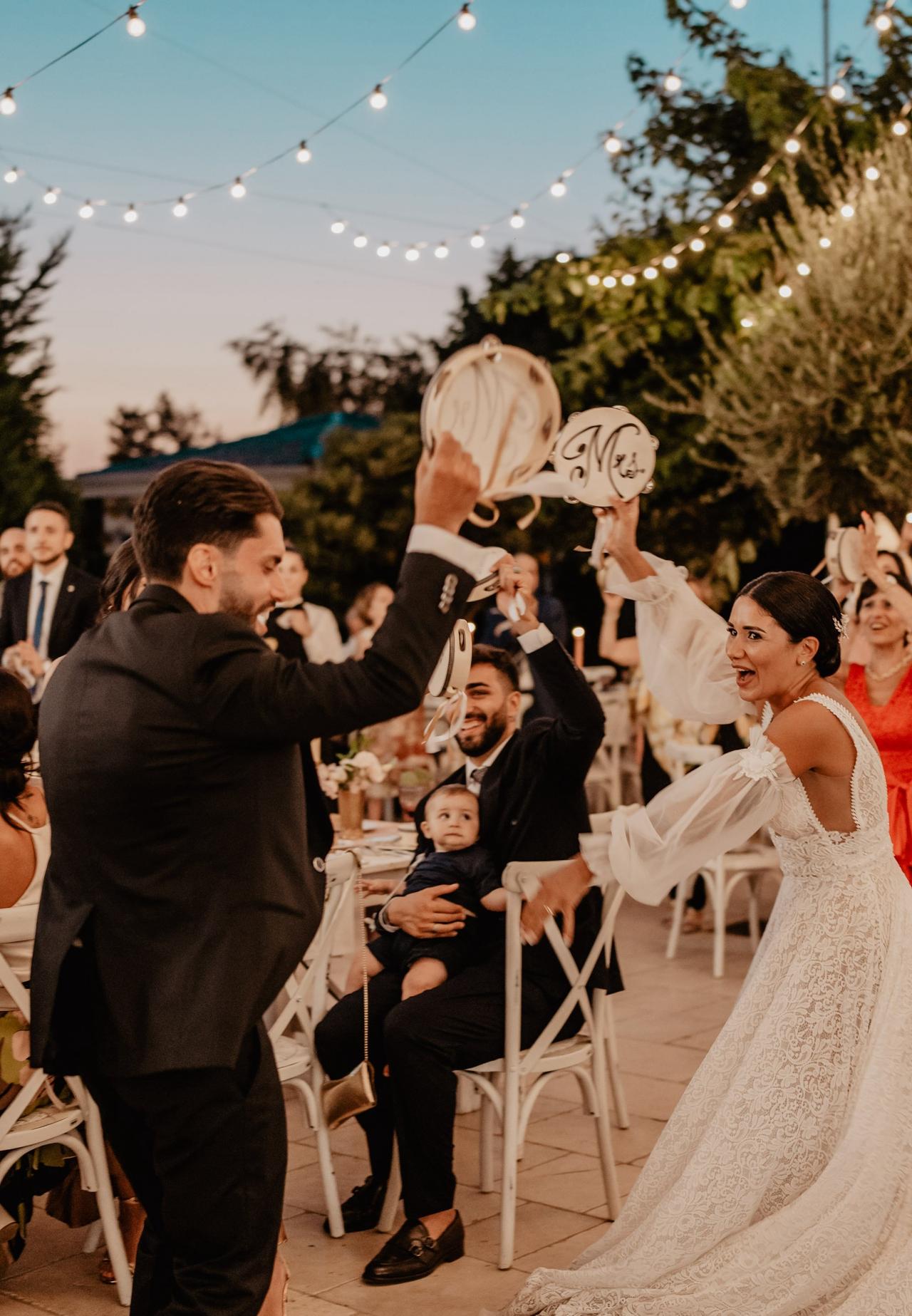 sposi che ballano con tamburelli in mano- stili matrimonio