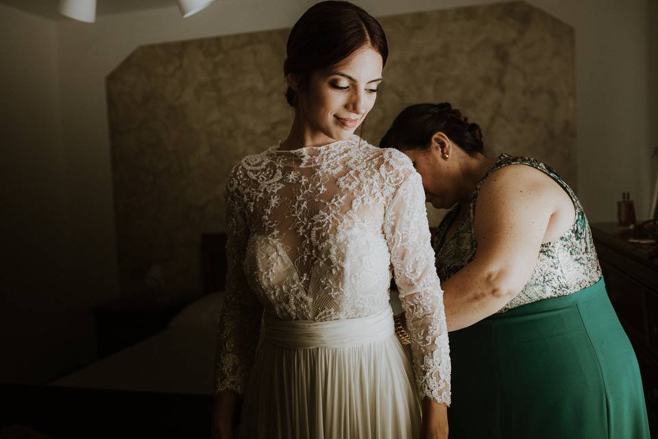 sposa con la madre che le chiude la cerniera dell'abito