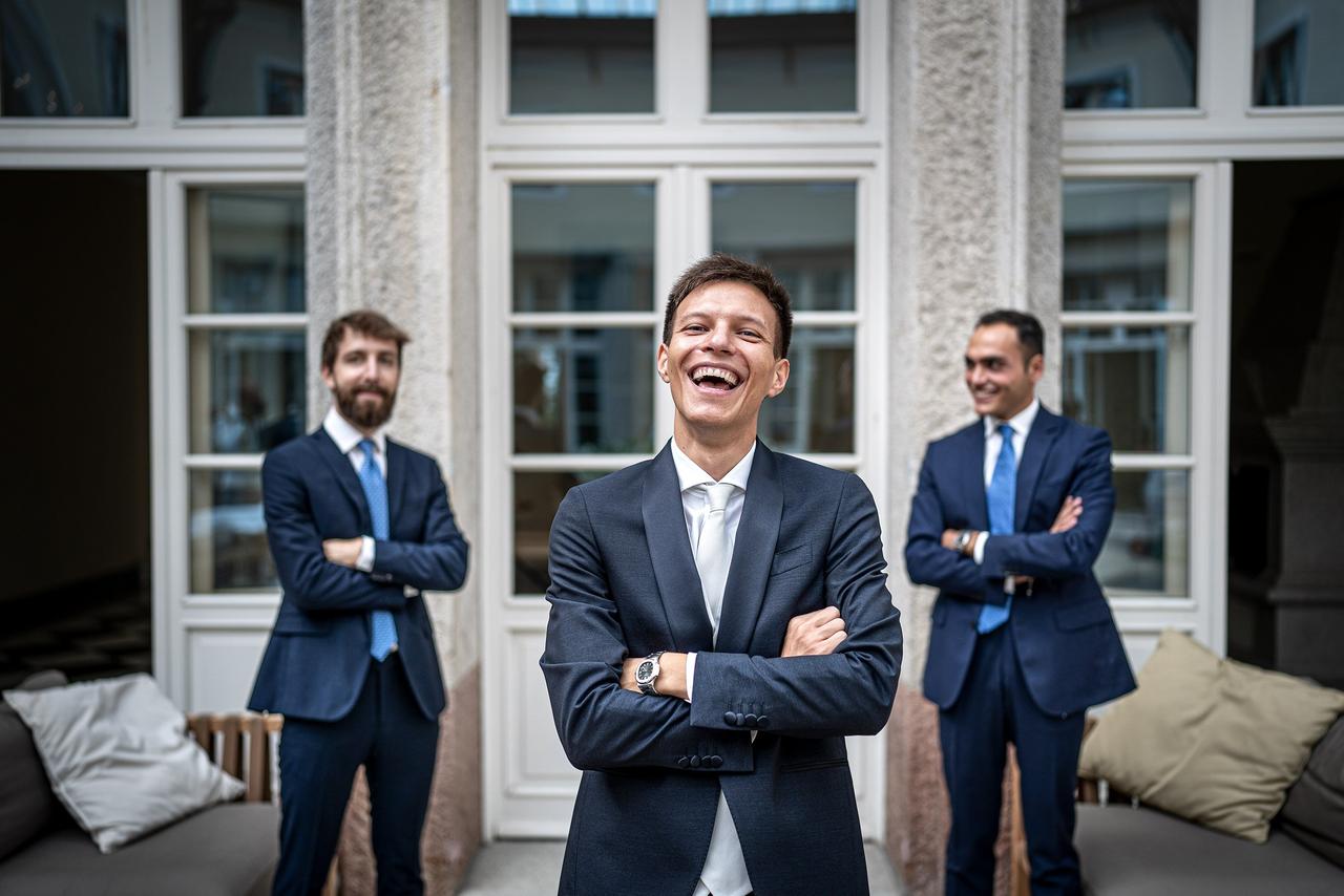 sposo e testimoni che sorridono con braccia incrociate