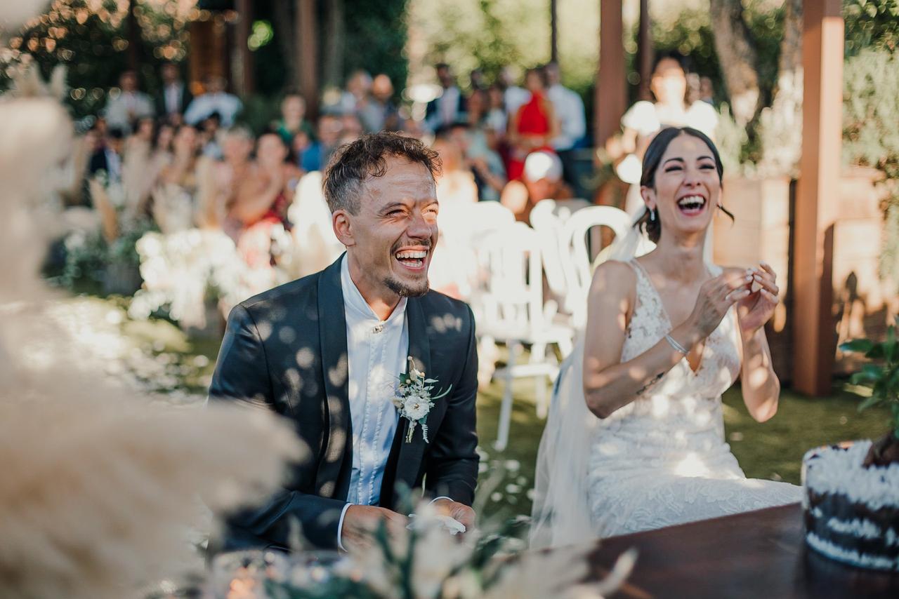 sposi che ridono durante cerimonia nuziale all'aperto