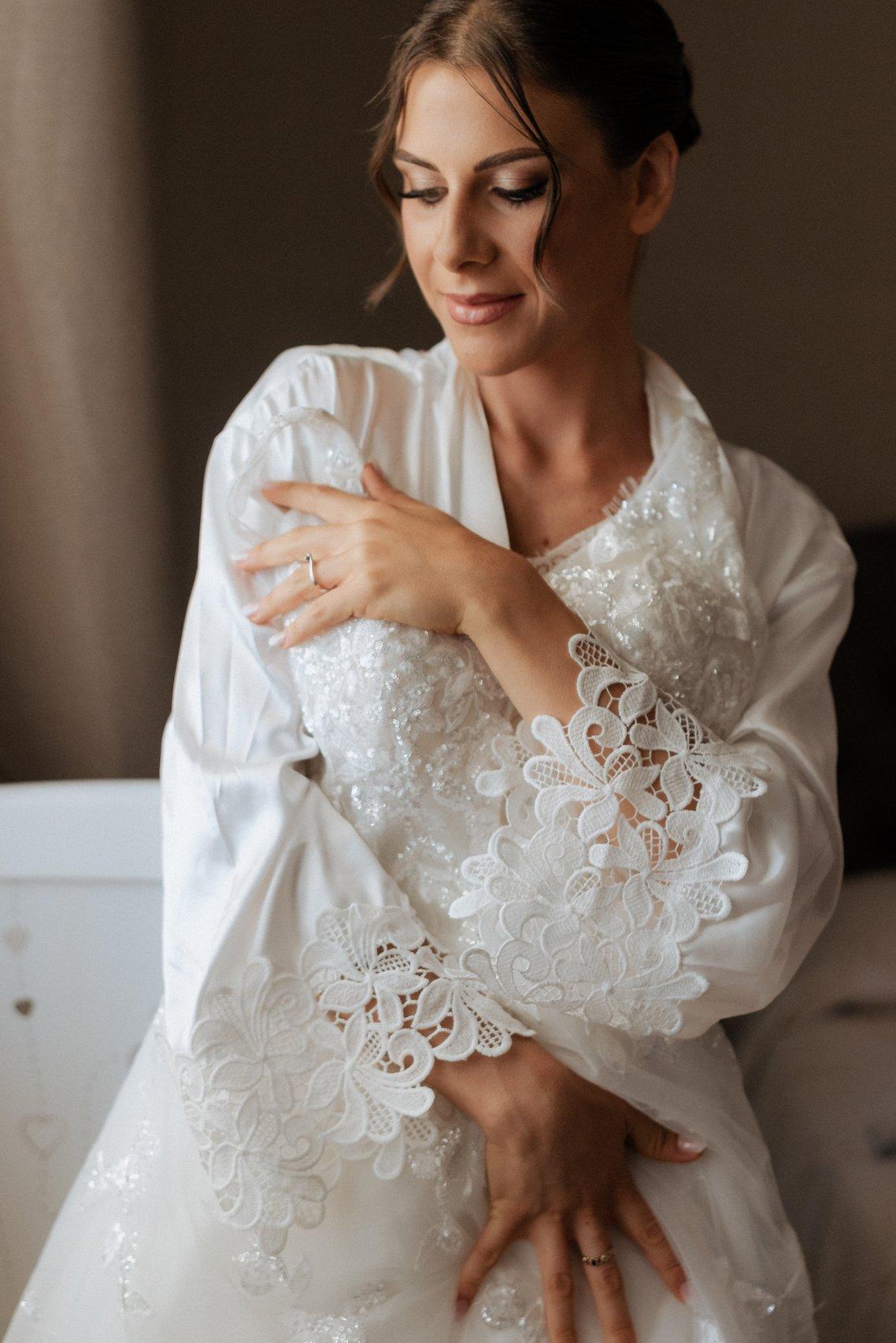 sposa durante la preparazione che indossa un anello fidanzamento con solitario