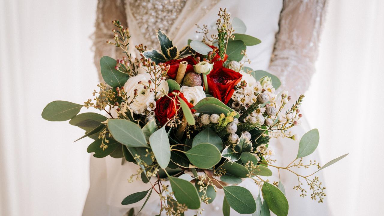 bouquet sposa invernale con bacche pigne rose rosse e bianche