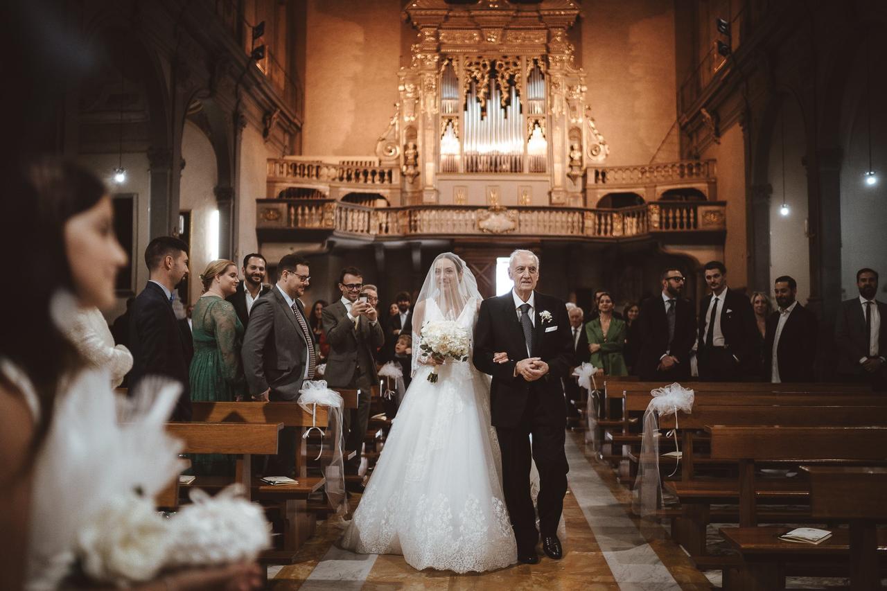 Sposi novelli kissing mentre si esce dalla chiesa dopo la cerimonia di  matrimonio, la famiglia e