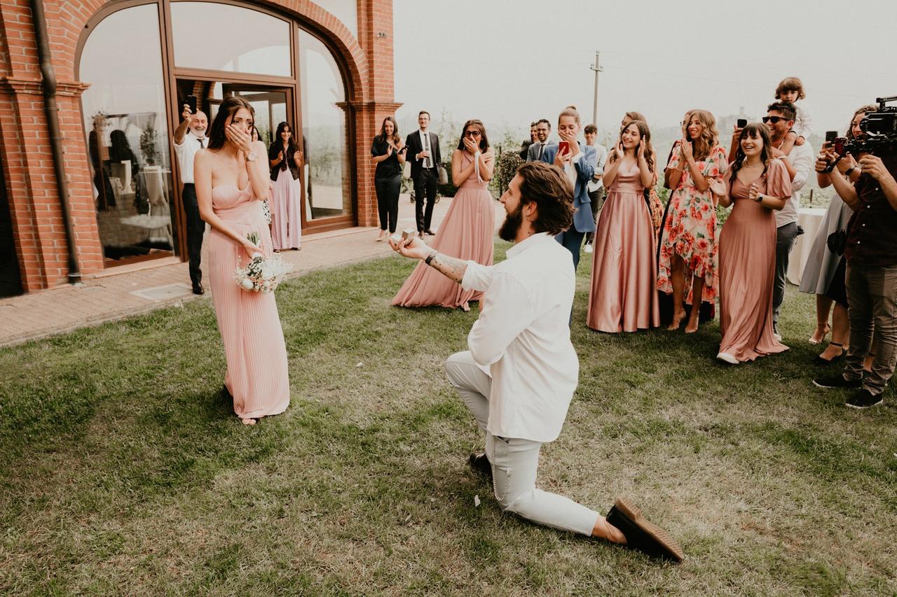 ragazzo che fa la proposta di matrimonio a una ragazza durante un matrimonio