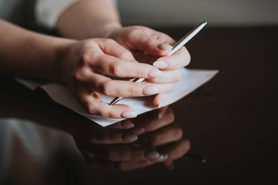 mani di una donna con una penna e una lettera