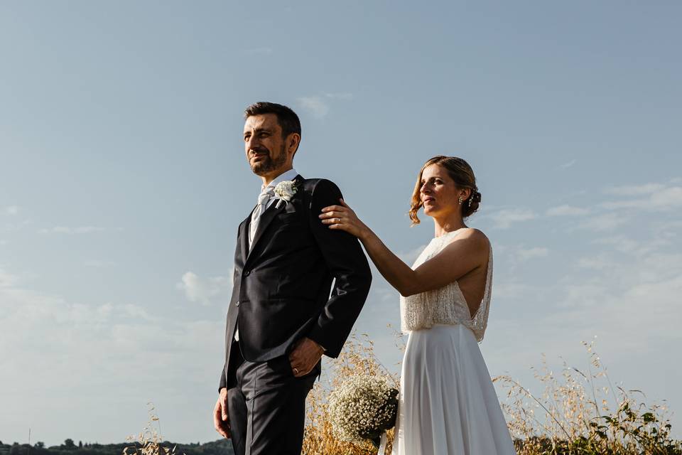 sposa che sta dietro allo sposo con la mano sul suo braccio- come chiedere scusa