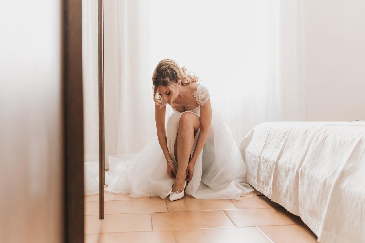 donna che allaccia le scarpe da sposa