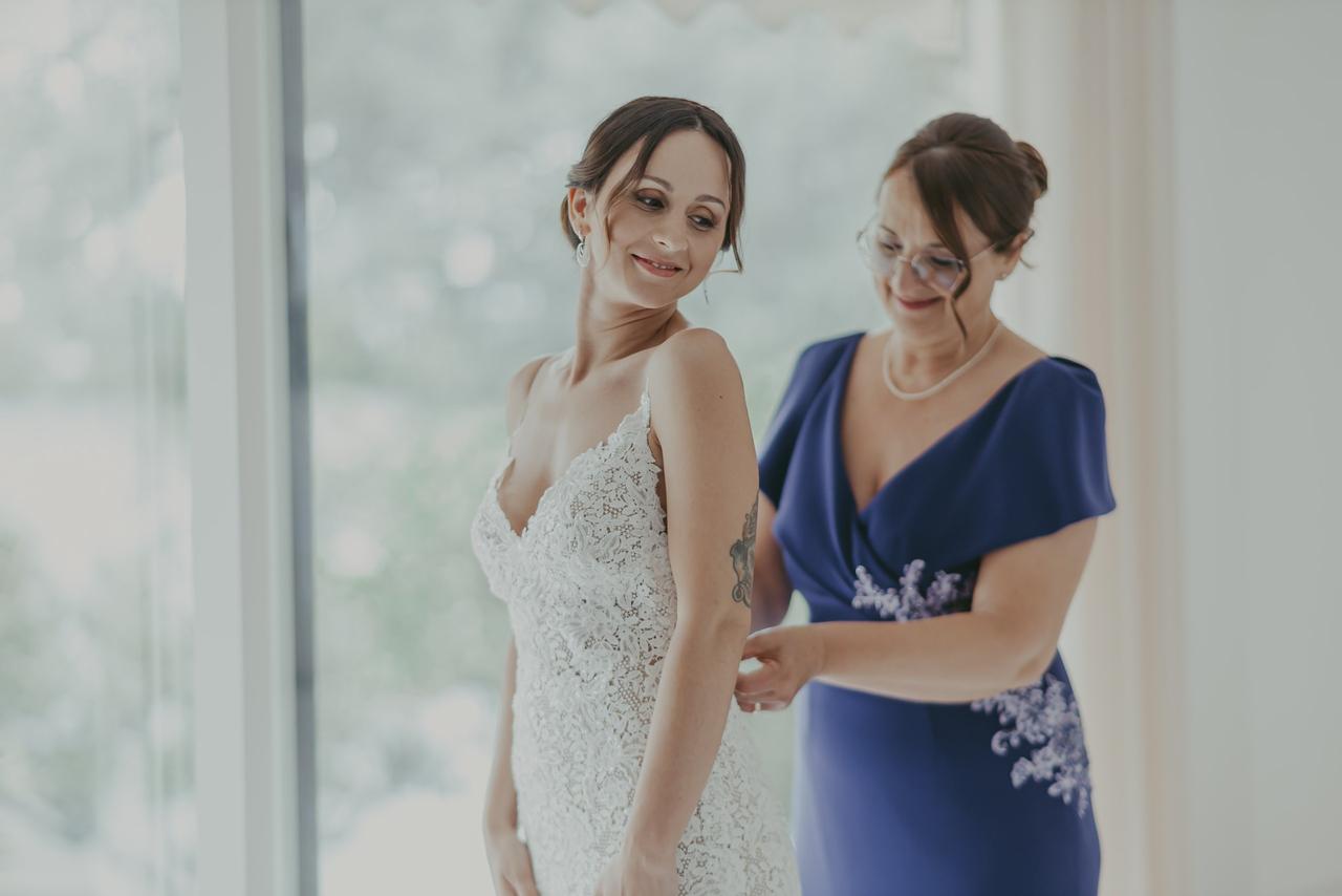 mamma che aiuta la sposa con il vestito- abito mamma sposa