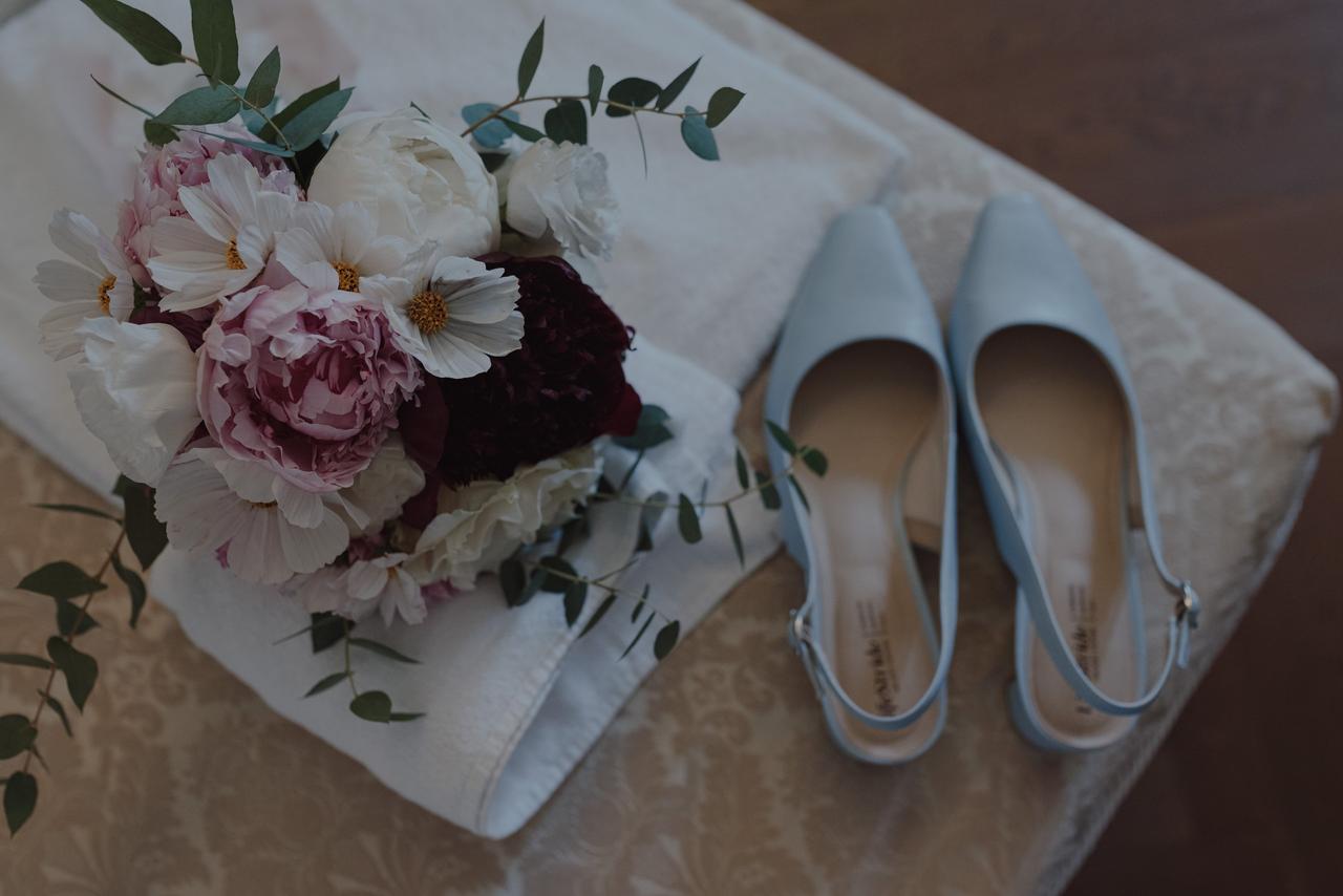 bouquet da sposa poggiato vicino alle scarpe da sposa