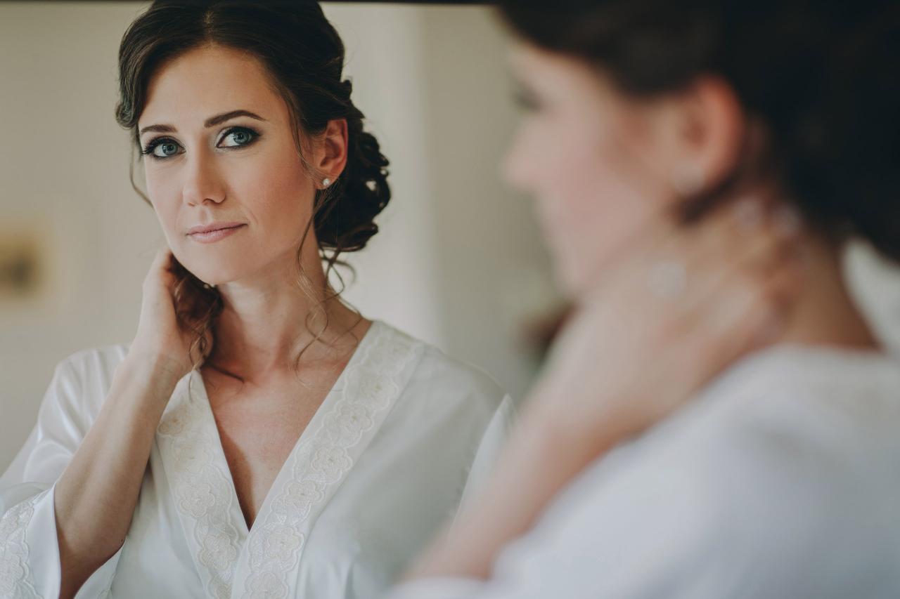 sposa truccata che si guarda allo specchio