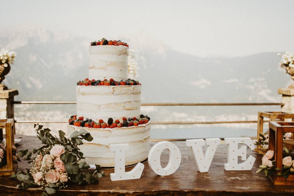 tavolo con torta nuziale e decorazioni floreali