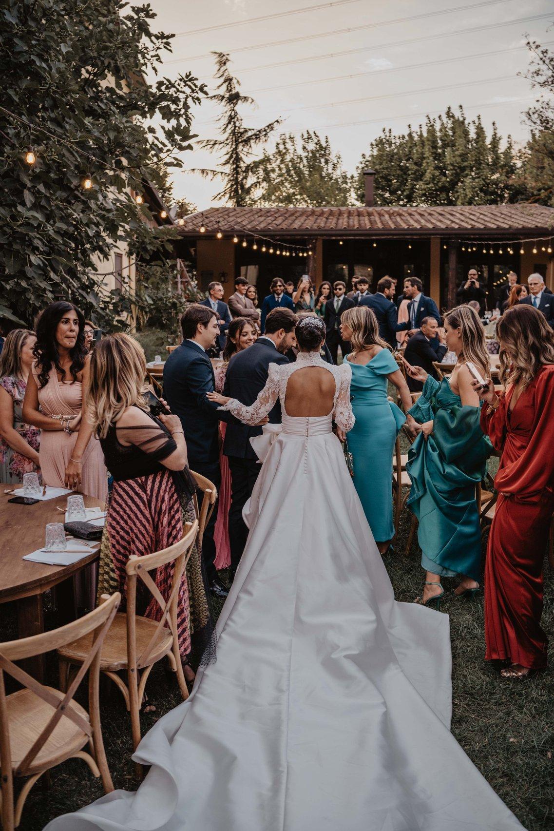 sposa con abito sposa con strascico lungo tra gli invitati