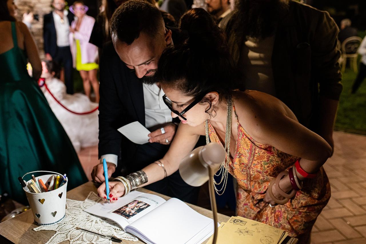 invitati che scrivono un pensiero sul guestbook matrimonio- intrattenimento matrimonio