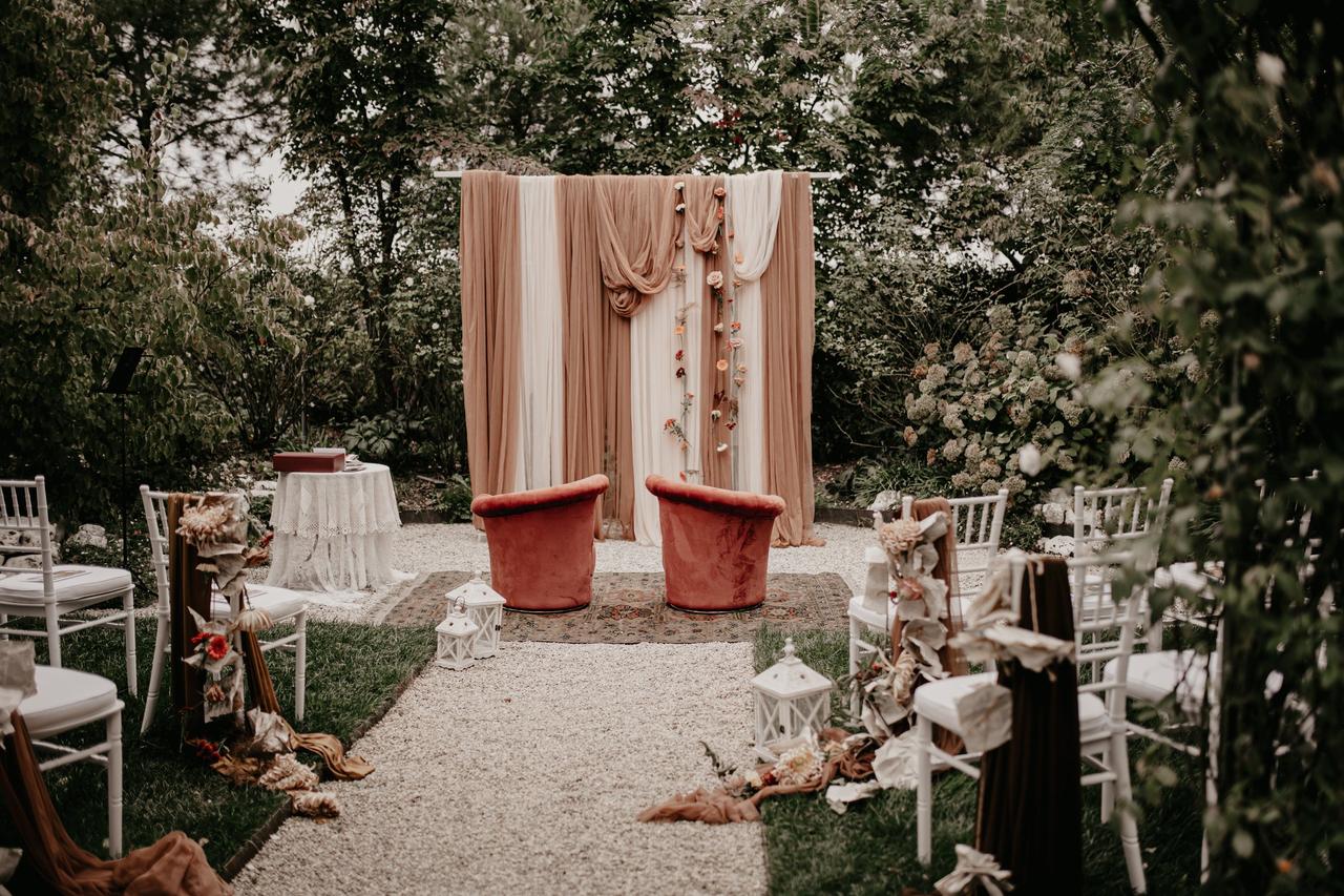 allestimento floreale matrimonio per cerimonia all'aperto con tessuti  rosa e bianchi e lanterne