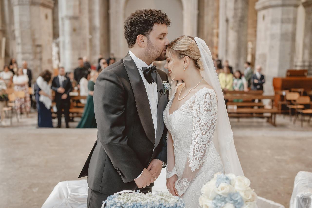 sposo bacia la sposa sulla fronte durante il rito in chiesa- cos'è il matrimonio concordatario