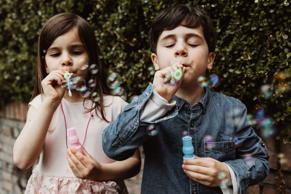 due bambini che giocano con le bolle di sapone