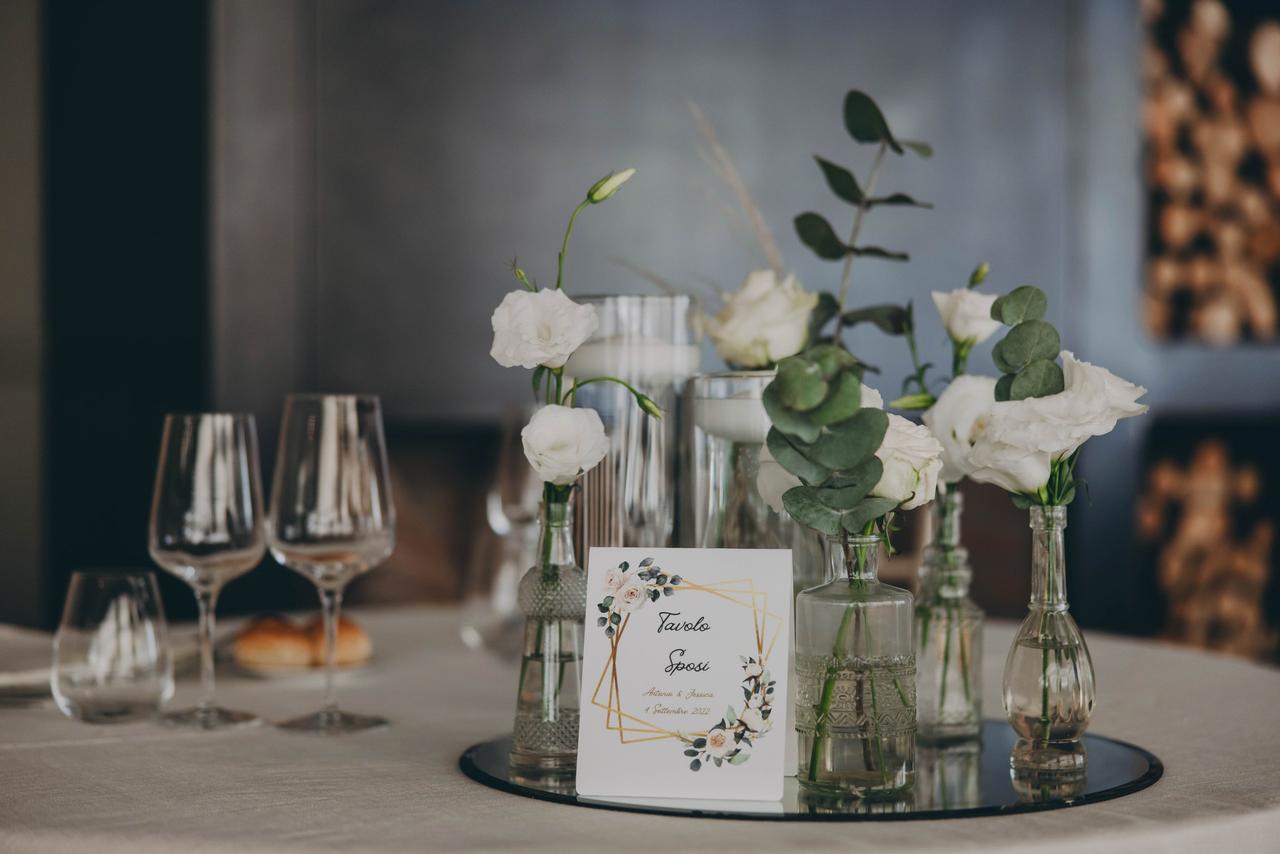Un tavolo con un vaso di fiori e un libro su di esso foto