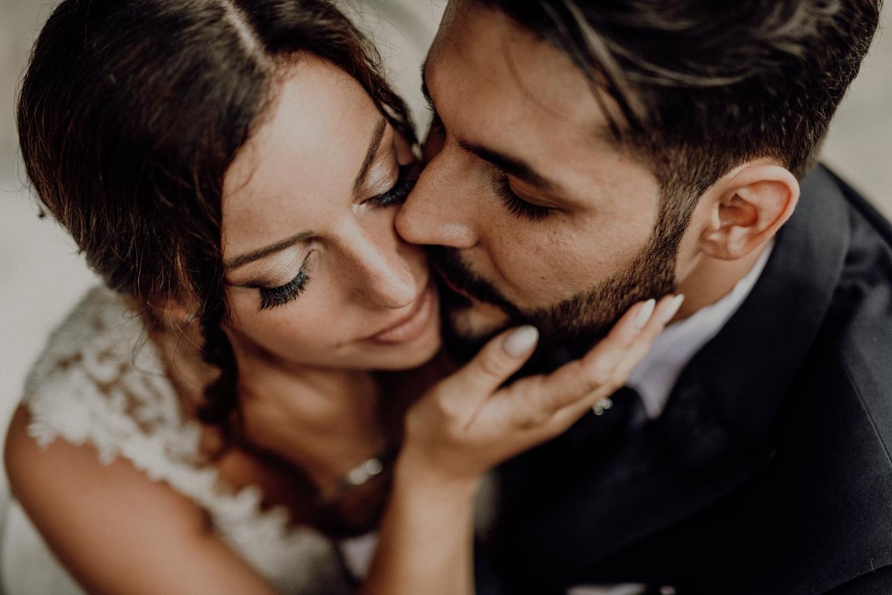 sposo che bacia sulla guancia la sposa- frasi promessa matrimonio