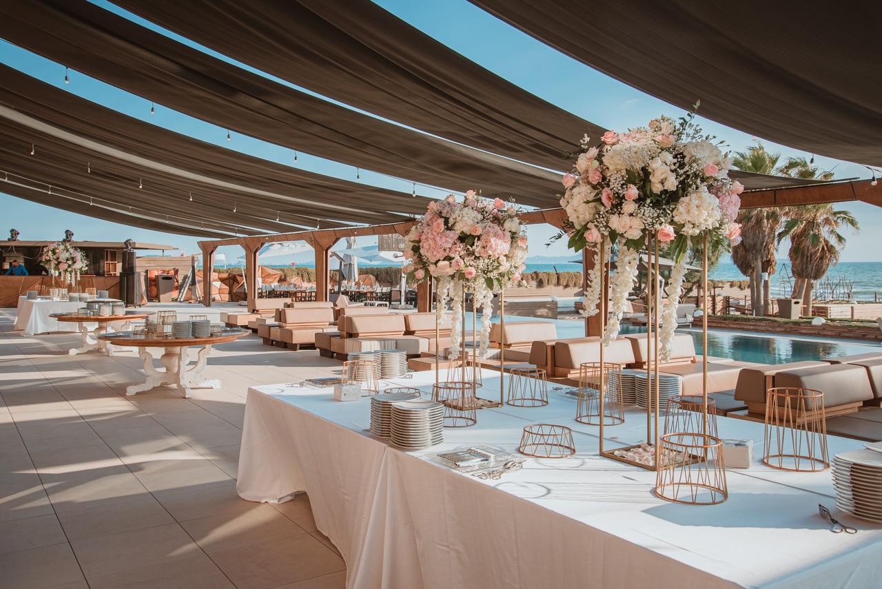 terrazza sul mare allestita con fiori sui tavoli per aperitivo- sposarsi al mare