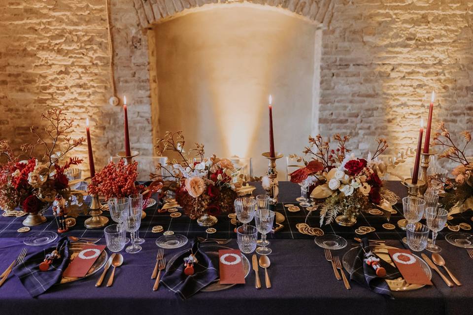 decorazioni tavola Natale con fiori, candelabri e tovaglia blu