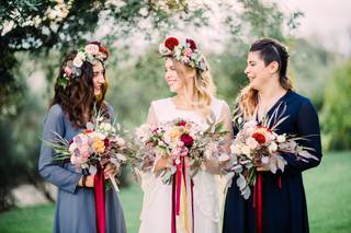 sposa con due damigelle che sorreggono tre bouquet