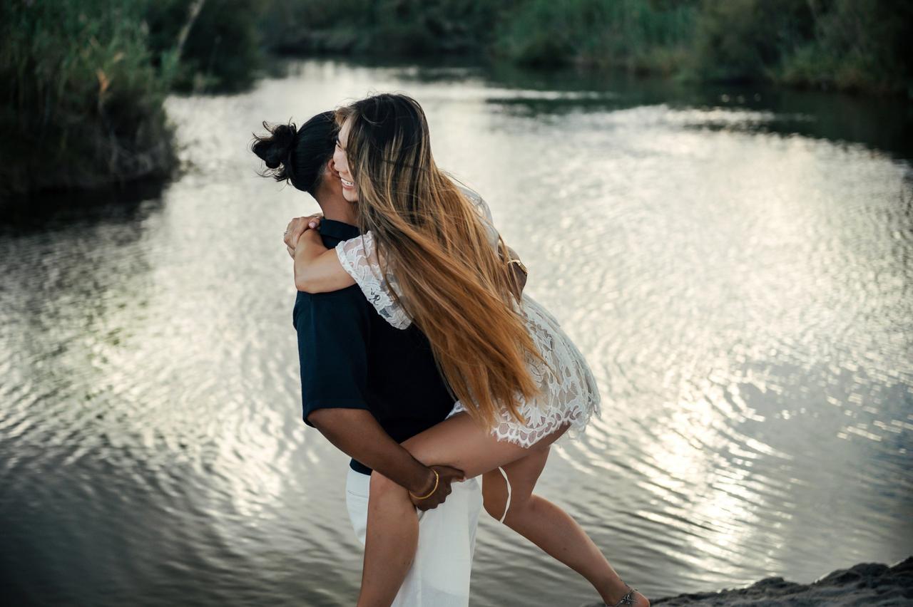 coppia che si abbraccia e ride sulla spiaggia- come conquistare una donna