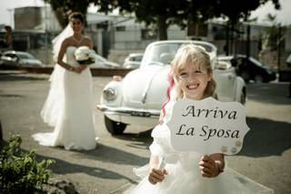 damigella bambina che porta il cartello arriva la sposa