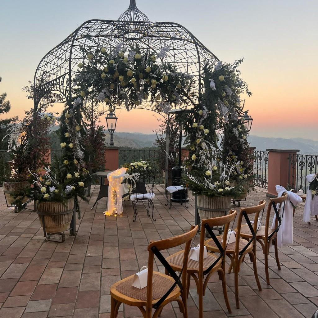 allestimento floreale matrimonio all'aperto con gazebo in ferro battuto decorato con rose bianche 