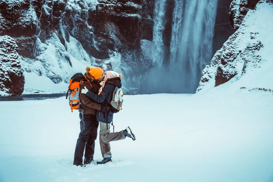 ragazzo e ragazza che si baciano in un paesaggio innevato