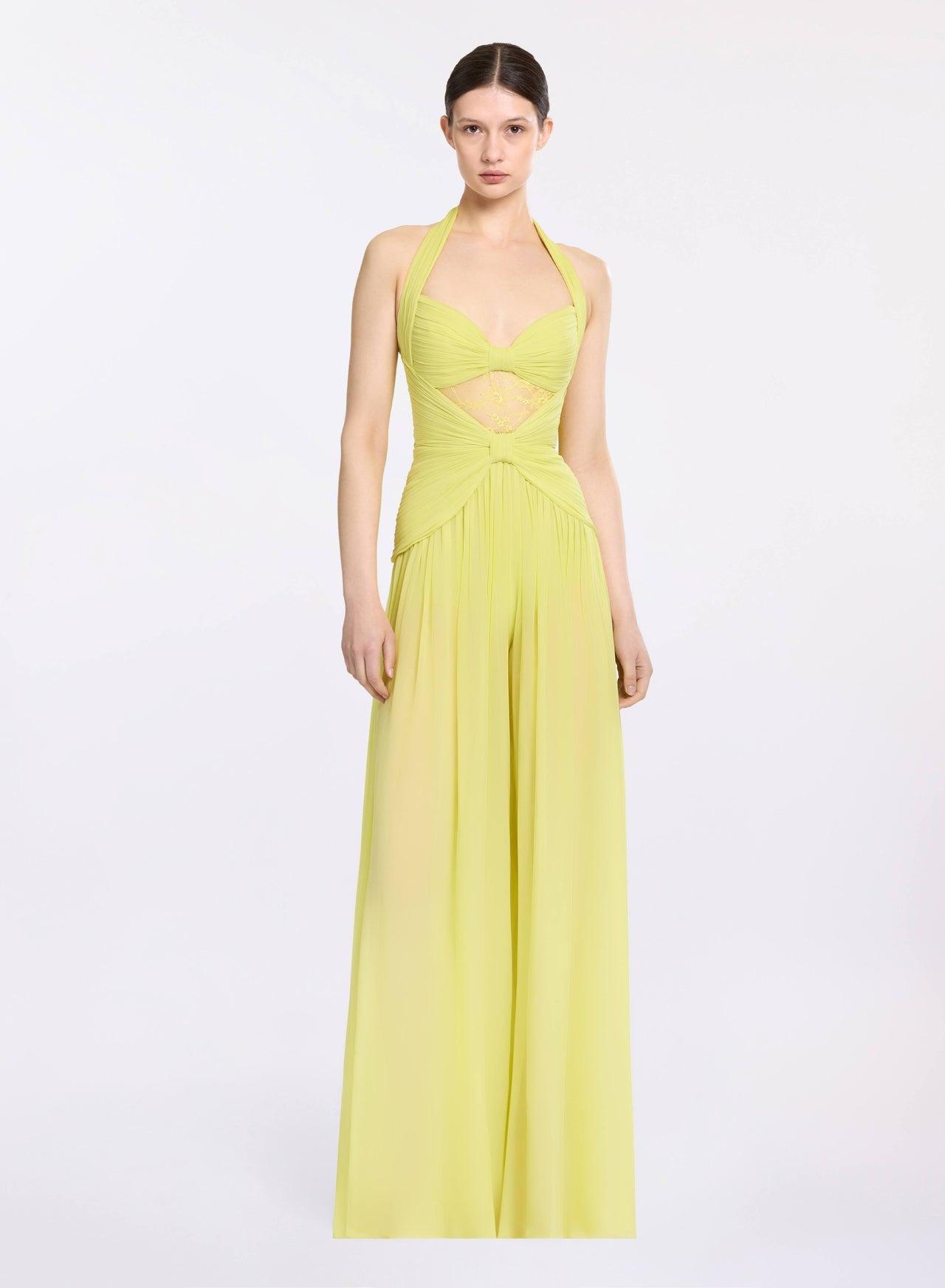 tuta elegante da cerimonia gialla, con top legato dietro al collo, cut out sul ventre e pantalone a palazzo 