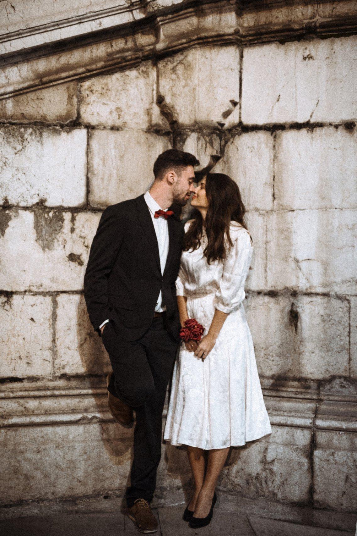sposi che si baciano e indossano abiti stile Granny core. stili matrimonio