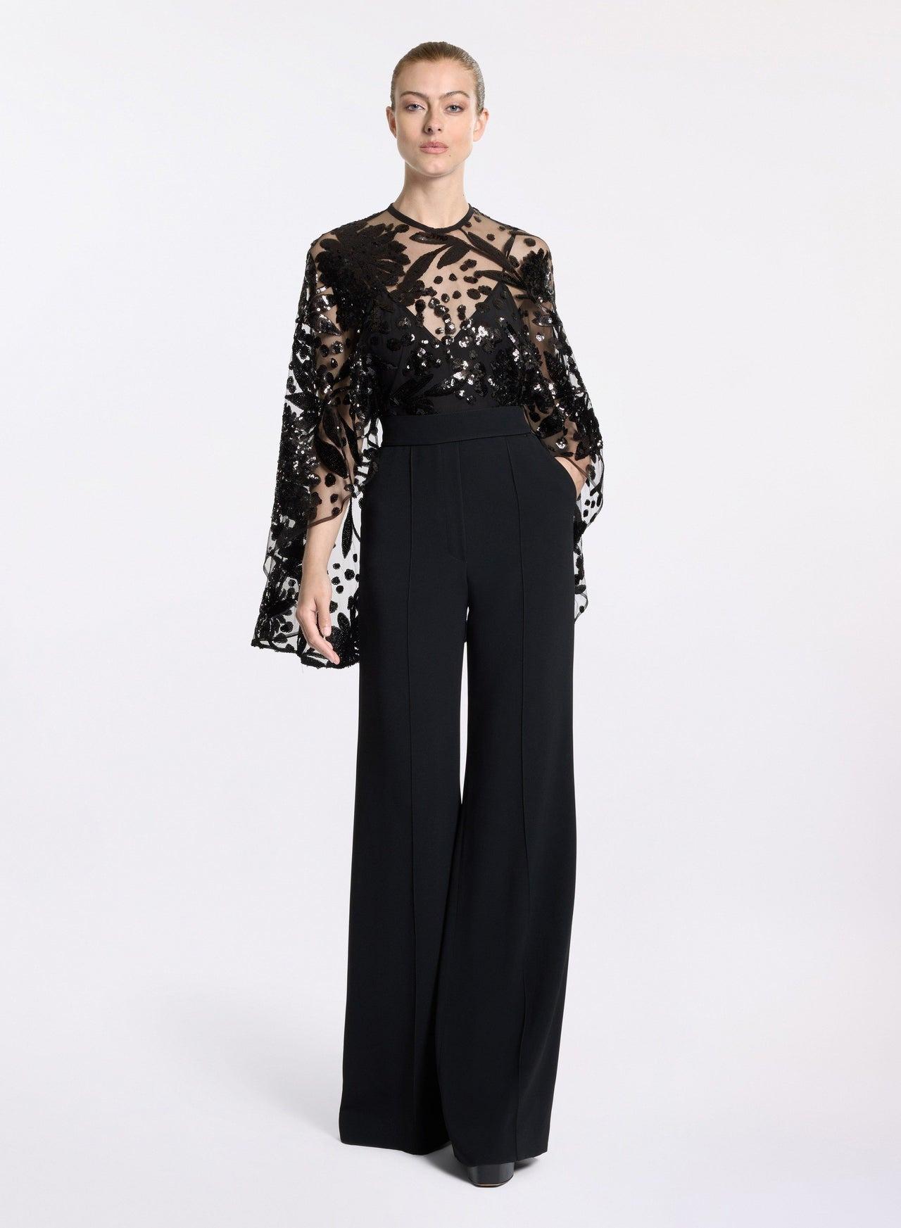 Tuta elegante da cerimonia nera, corpetto trasparente con effetto mantello con ricami e paillettes, pantaloni svasati