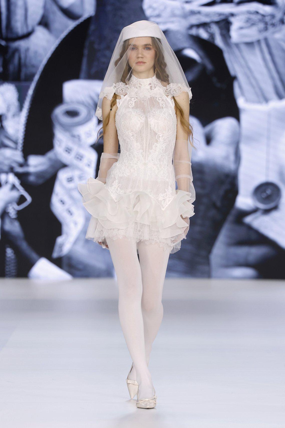 abito da sposa corto in pizzo con scollo all'americana, semi trasparente
