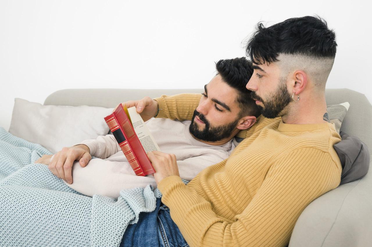 coppia omosessuale che legge insieme un libro sul divano- come cambia il sesso dopo il matrimonio