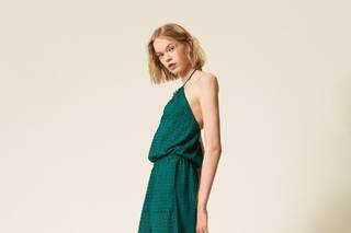 tuta elegante da cerimonia verde smeraldo in crochet, scollo halter e pantaloni ampi con tasche