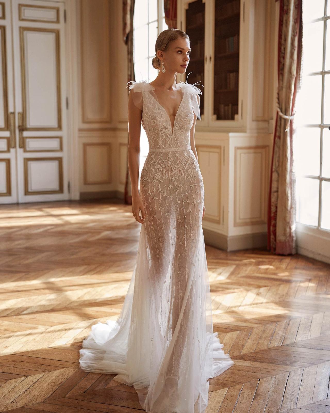 abito da sposa con piume sulle spalle, modello a sirena con scollo profondo