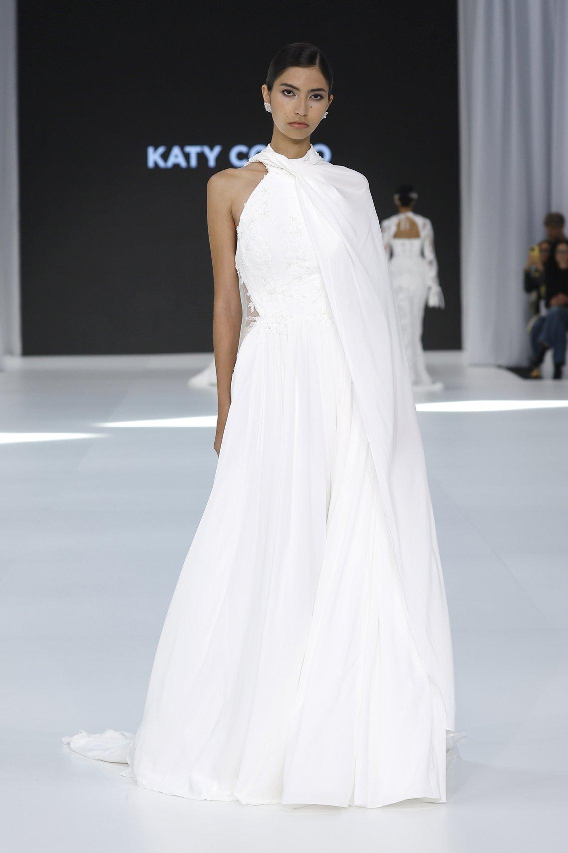 abito da sposa boho chic con gonna morbida in chiffon scollo all'americana e mantella su una manica