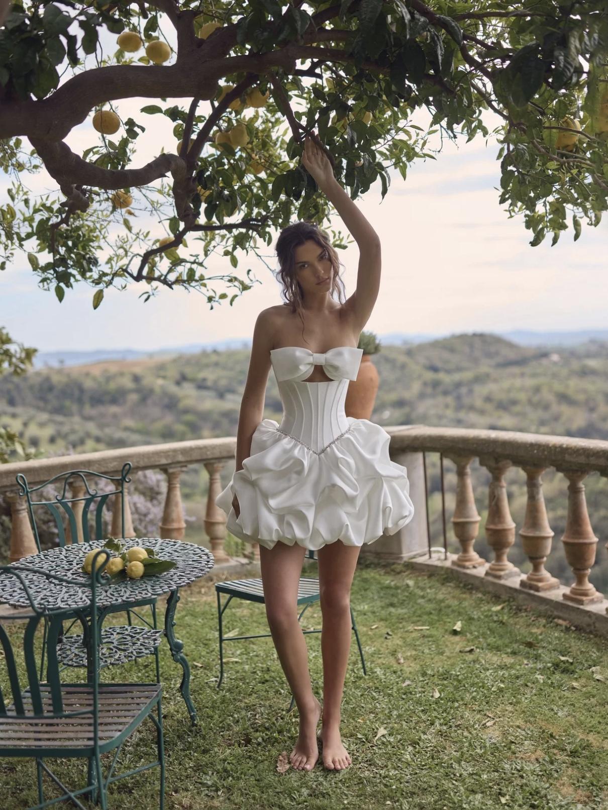 abito da sposa corto con gonna gonfia e corsetto con fiocco