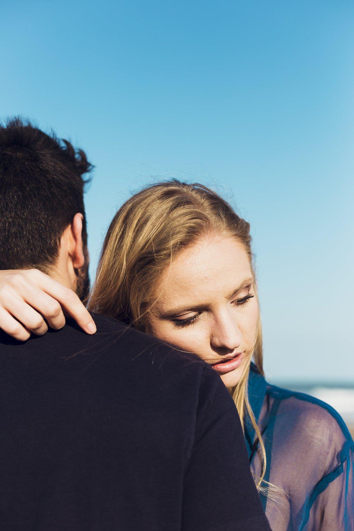 ragazza che abbraccia il suo ragazzo con volto triste