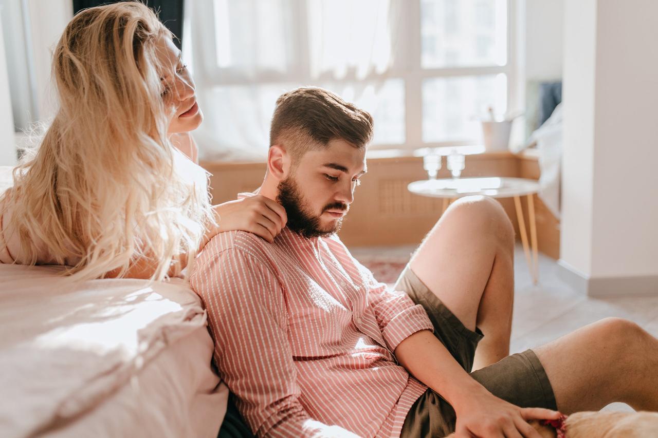 ragazza sul letto che accarezza la spalla del ragazzo seduto per terra- come cambia il sesso dopo il matrimonio