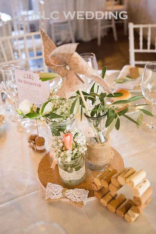 centrotavola invitati con base in sughero e merletto, cuore di sughero, girandola e segnatavolo con 