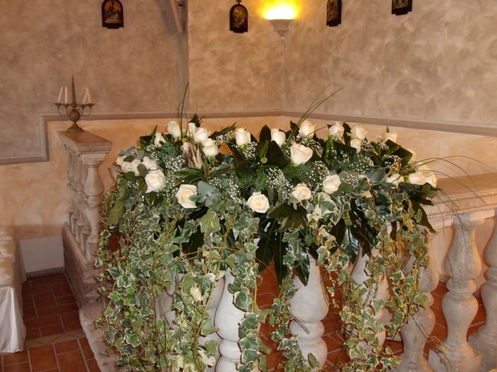 composizione floreale di rose bianche, peperoncini verdi e  con ederina pendentein un chiesa antica 