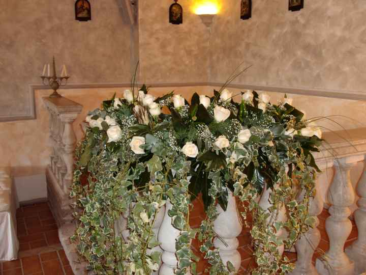 composizione floreale di rose bianche, peperoncini verdi e  con ederina pendentein un chiesa antica 