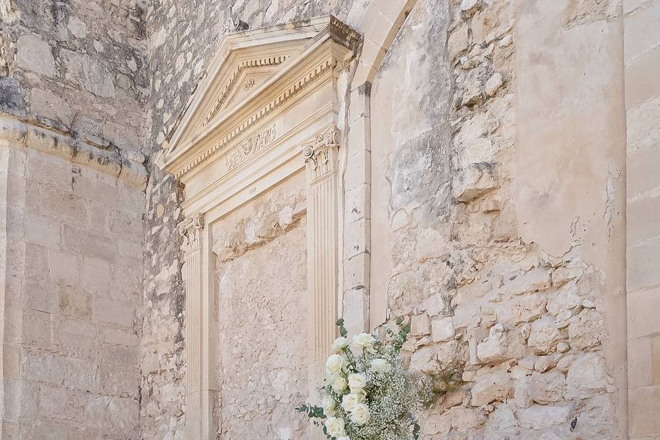 Persona_tratta_fiori_arco_esterno