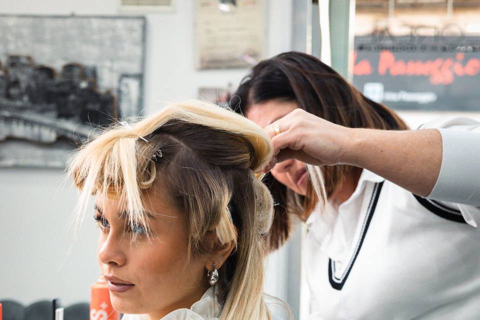 Parrucchiera che intreccia i capelli