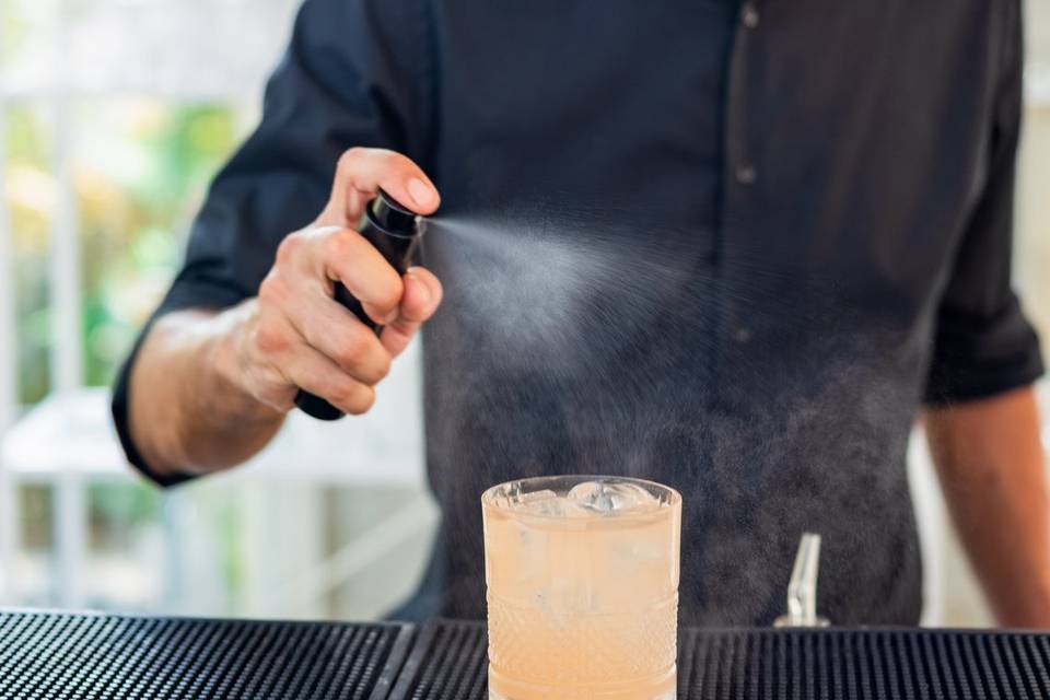 Barista che affumica un cocktail