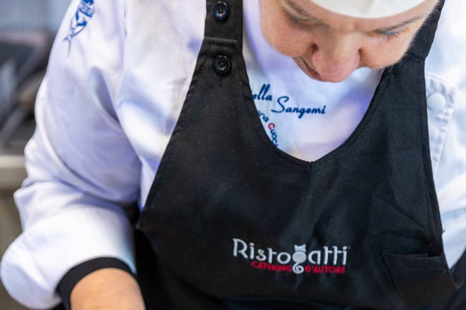chef guarnisce ravioli piatto bianco